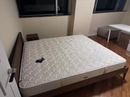 A wooden bed frame and a mattress image 1