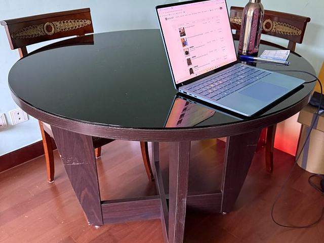 Round dark wood dining table with back glass top