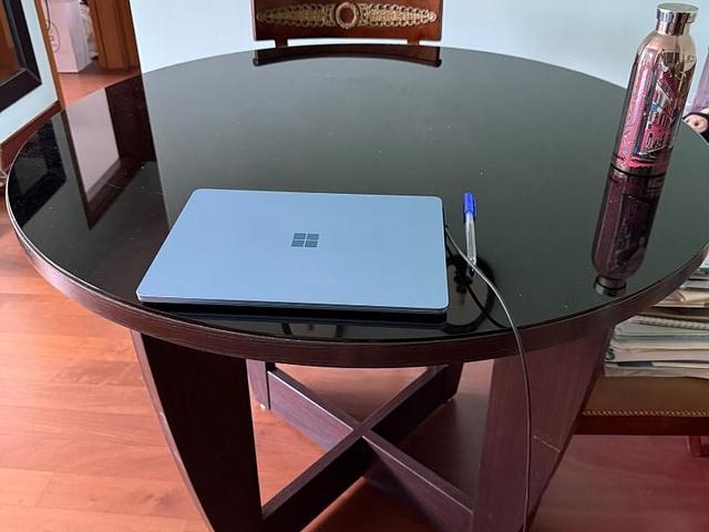 Round dark wood dining table with back glass top
