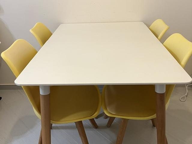 Well Used White dining table w/ four yellow chairs